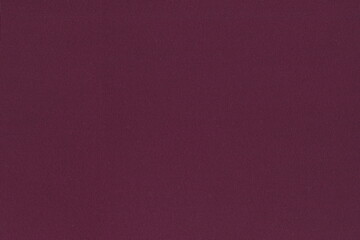 The texture of natural knitted fabric is a beautiful maroon color. Abstract monochrome background of soft wine-colored Burgundy fabric.