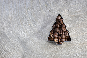 christmas greeting card template with coffee beans filled into a cookie cutter on a grey wood...