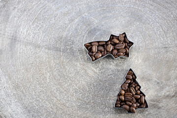 postcard template for Christmas with coffee beans filled into a cookie cutter on a grey wood slice, shooting star shape and Christmas tree  and copy text space
