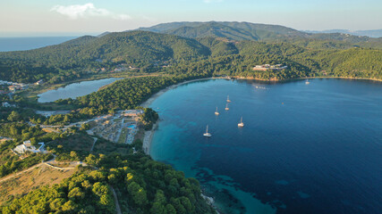 Obraz premium Zdjęcie lotnicze drona pięknej popularnej zorganizowanej piaszczystej zatoki, turkusowej plaży i rezerwatu przyrody z sosnami Koukounaries, wyspa Skiathos, Sporady, Grecja