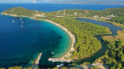 Aerial drone photo of beautiful popular organised sandy bay, turquoise beach and natural preserve lake with pine trees of Koukounaries, Skiathos island, Sporades, Greece