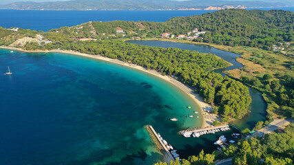 Aerial drone photo of beautiful popular organised sandy bay, turquoise beach and natural preserve lake with pine trees of Koukounaries, Skiathos island, Sporades, Greece