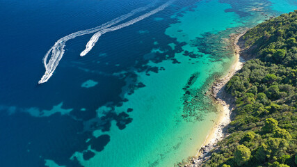 Aerial drone photo of secluded rocky cove near turquoise pebble paradise beach of Kastani covered with pine trees, Skopelos island, Sporades, Greece
