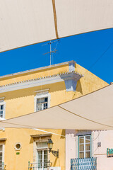 Fototapeta na wymiar Canvases stretched for sun protection in the alleys of the old town of Faro, Algarve, Portugal