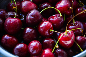 Red ripe cherries with twigs in a Cup and on the table