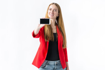 Naklejka premium Portrait of a smiling girl who is standing with her hand outstretched forward holding a phone on a white background