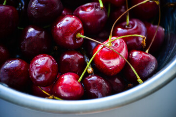Red ripe cherries with twigs in a Cup and on the table