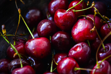 Red ripe cherries with twigs in a Cup and on the table