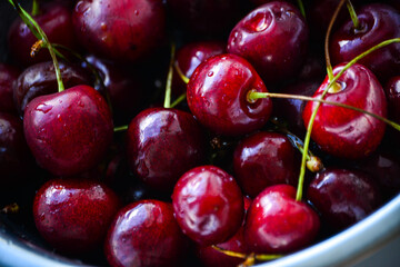 Red ripe cherries with twigs in a Cup and on the table