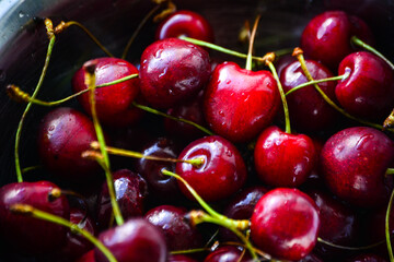 Red ripe cherries with twigs in a Cup and on the table