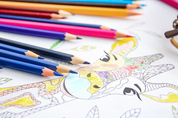 Coloring picture and pencils on table