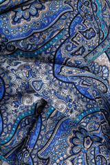 top view closeup on crumpled blue cotton scarf with bright oriental ornament