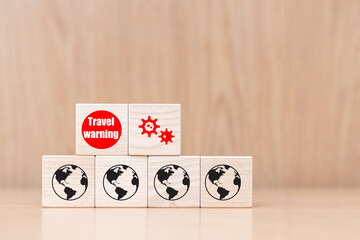 Wooden Cubes with covid-19 coronavirus and travel warning on wooden background