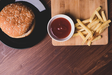 french fries and a burger on wooden surface