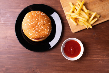 french fries and a burger on wooden surface