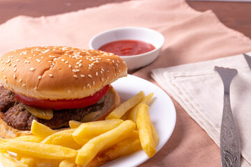 traditional fat burger and french fries on beige textile cloth