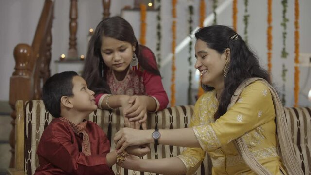  sister tying rakhi, Raksha bandhan to brother's wrist during festival or ceremony - Raksha Bandhan celebrated across India as selfless love or relationship between brother and sister