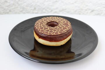 Donut with chocolate on a black plate