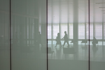 Fototapeta premium Silhouetted businesspeople in corporate office lobby