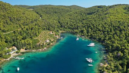 Aerial drone photo of safe small fjord harbour of Mplo near bay of Panormos a popular yacht and sail boat anchorage with calm sea covered with pine trees, Skopelos island, Sporades, Greece