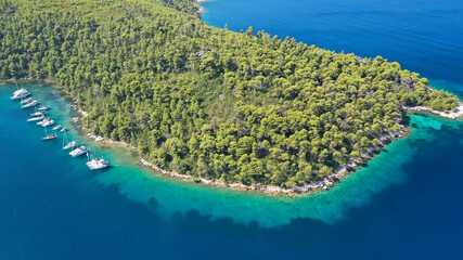 Aerial drone photo of safe small fjord harbour of Mplo near bay of Panormos a popular yacht and sail boat anchorage with calm sea covered with pine trees, Skopelos island, Sporades, Greece