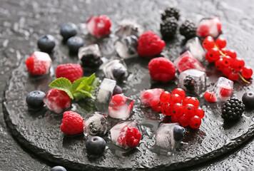 Ice with frozen berries on dark background