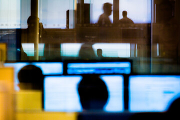 Business people using computers seen through glass wall at office