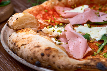 Italian pizza with mortadella and cheese on dark a wooden table. Healthy food