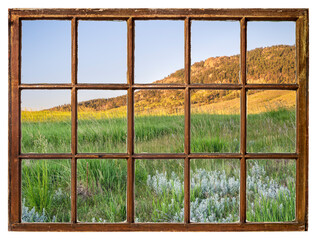 early summer scenery of Rocky Mountains foothills in northern Colorado as seen from a vintage sash window
