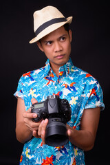 Young Asian tourist man ready for vacation against black background