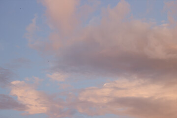 Naklejka na ściany i meble Evening clouds against the blue sky
