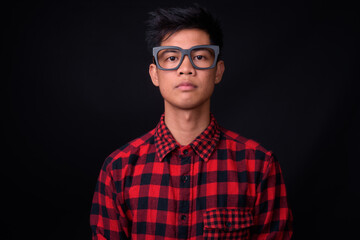 Obraz premium Portrait of young Asian hipster man against black background