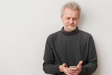 senior man with mobile phone on a white background