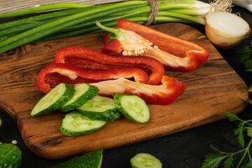 Sliced Cucumber with Green Vegetables on Rustic Cutting Board