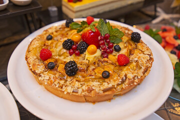 Fresh Fruit Tart with berries on white plate.