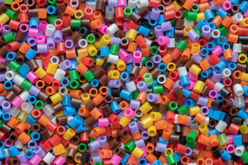 Fototapeta na wymiar multi-colored plastic beads, small pieces of plastic mosaic, background for children's creativity, the development of fine motor skills