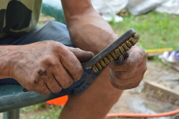 Auto mechanic cleaning screw. Selective focus, dirty hands
