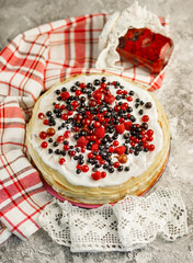 Pancakes with berries and strawberry jam on a gray background.