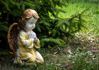 Garden utensils, an angel prays under the tree