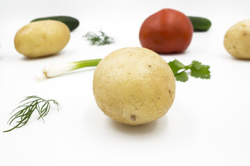 Fresh vegetables on a white background, flat lay: Potatoes, green onions, dill, tomato, parsley. Healthy food, vegan food.