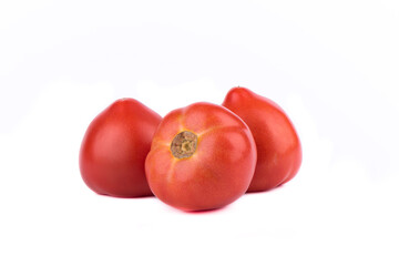 Three ripe red tomatoes are isolated on a white background.