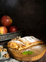 Traditional pieces of apple strudel with cinnamon, grits, powdered sugar and mint.