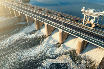 Hydroelectricity power station gates with flowing water, aerial view.