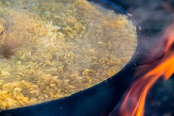 cauldron with pilaf on fire