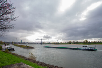 Fototapeta na wymiar Amazing scene with Rhine river and long vessel - dry cargo ship in Dusseldorf, Germany. Autumn beginning 