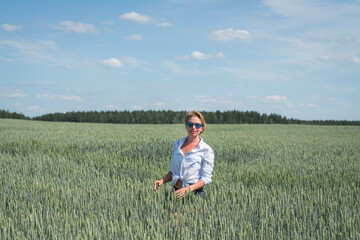 Naklejka na ściany i meble young woman walking in a wheat field