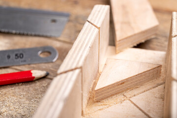 Cutting boards with a handsaw at an angle in the template. Minor carpentry work in the workshop....