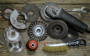angle grinder with different discs and tools on the old wooden background