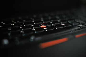 close up of a computer keyboard and trackpoint - red trackpoint on Thinkpad laptop 