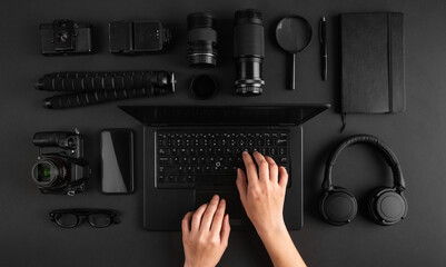 Top view of female hands working on laptop on minimal photographers desk